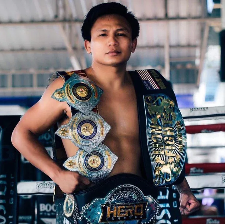 lerdsila holding his muay thai belts