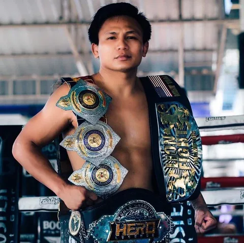 lerdsila holding his muay thai belts